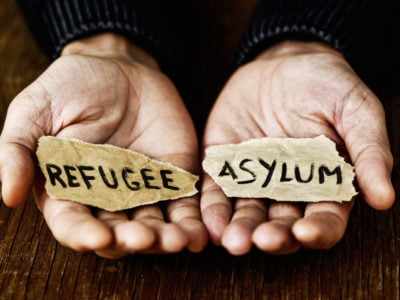 pieces of paper with words refugee and asylum